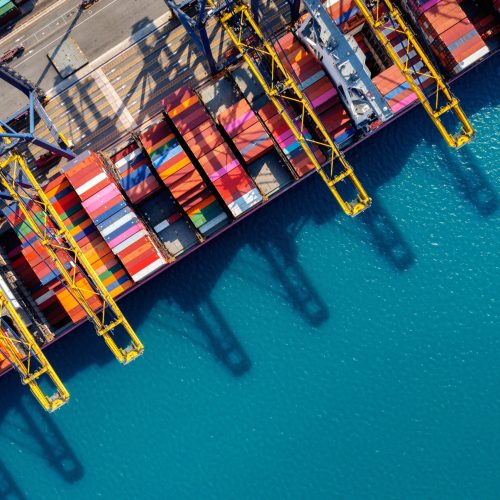 Aerial view of cargo ship and cargo container in harbor.